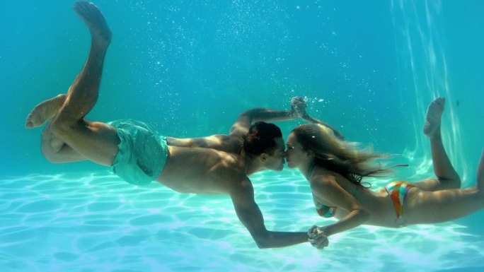 一对情侣在游泳池水下接吻的慢镜头