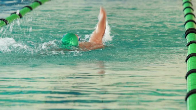 健康的游泳者在休闲中心的游泳池里做仰泳