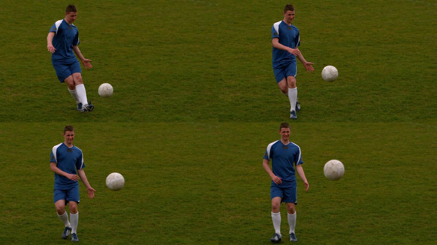 穿蓝色衣服的足球运动员在球场上用慢动作踢球