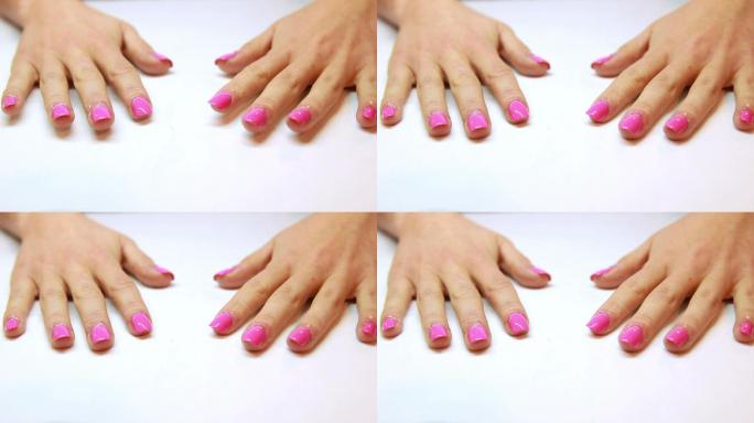 在美甲沙龙展示了新鲜的粉红色指甲的手