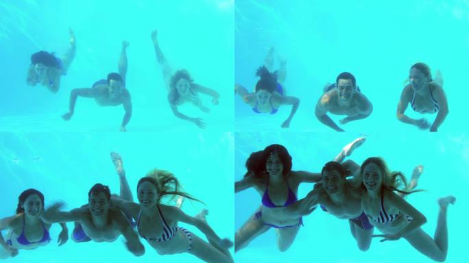 三个朋友在度假时跳进游泳池里挥手