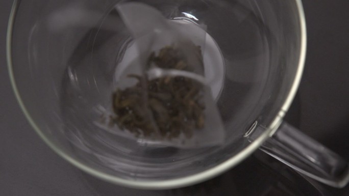 袋泡茶在慢镜头中落入玻璃杯