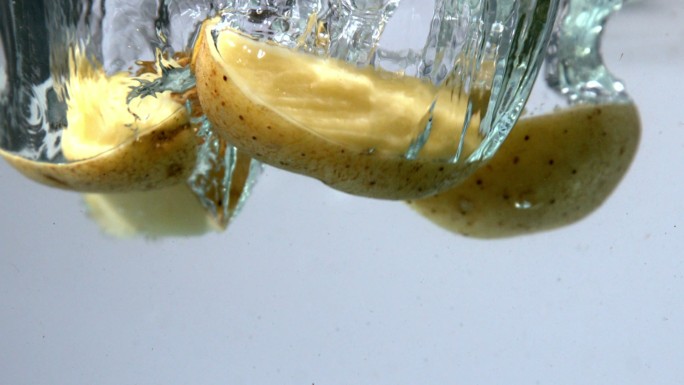 土豆片落在水中的慢镜头白色背景