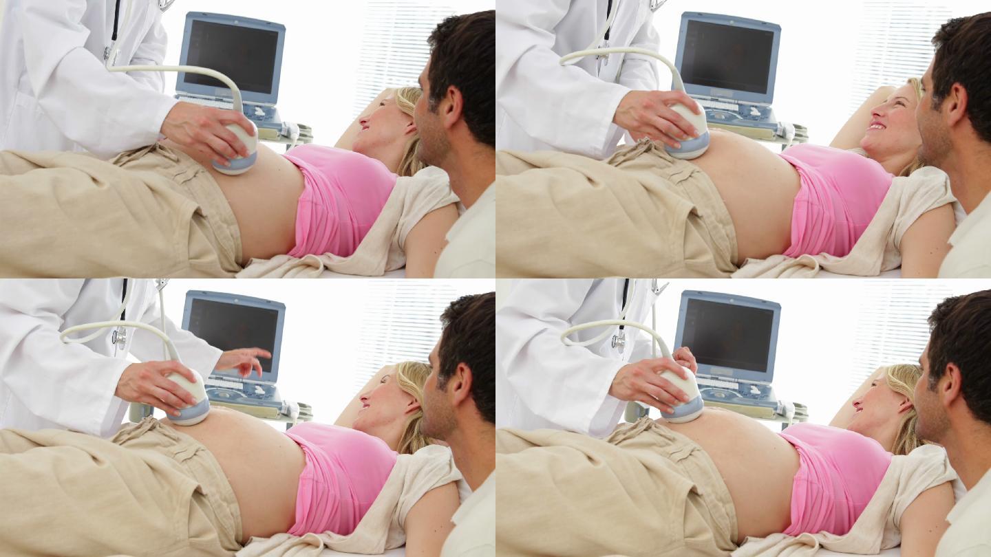 一名金发孕妇和她的伴侣在医院的办公室里做超声波扫描