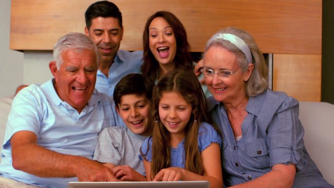 一个大家庭一起在沙发上慢镜头地使用笔记本电脑