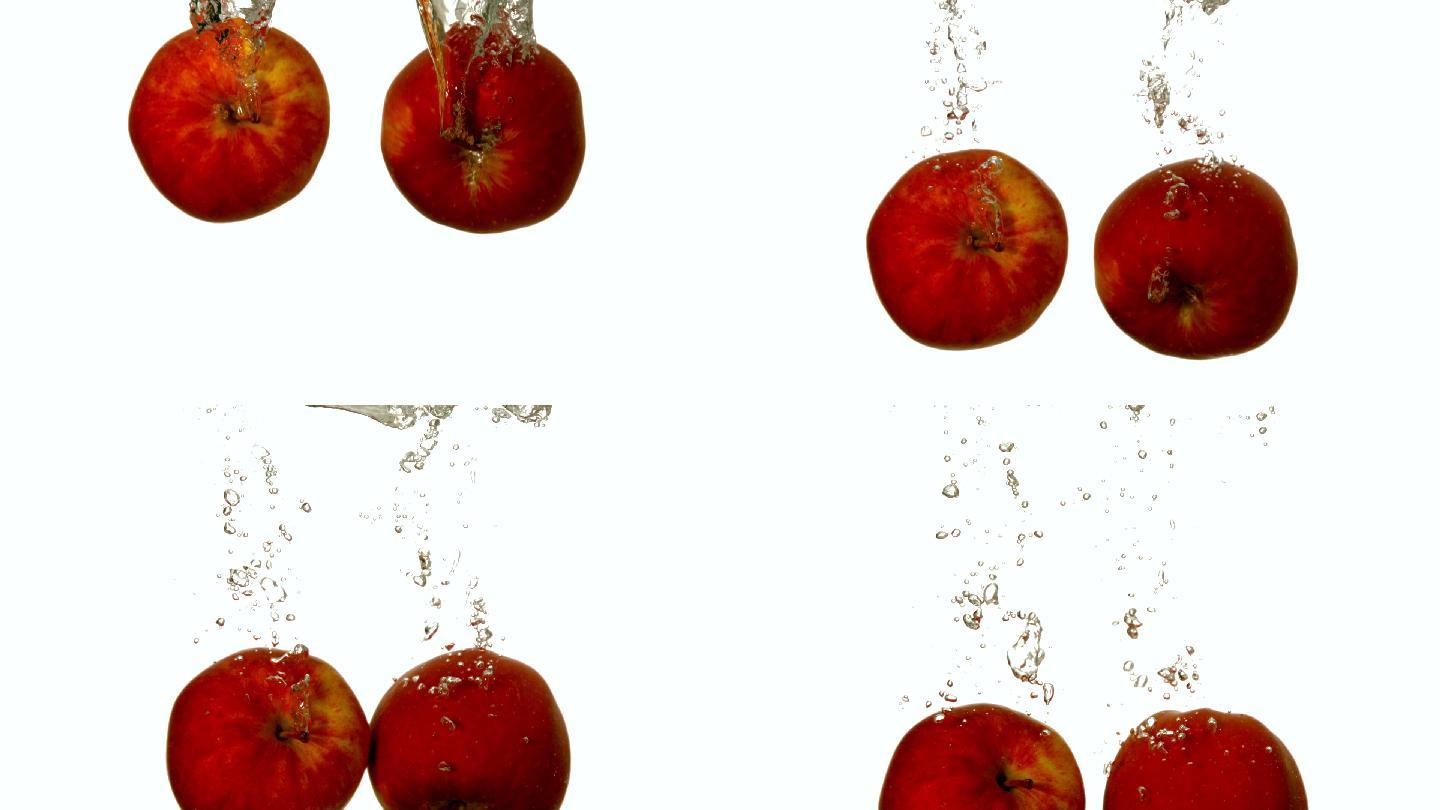 白色背景下的慢镜头，红苹果坠入水中