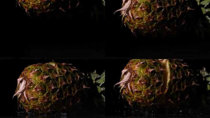 在慢镜头中，菠萝在黑色背景上落下并裂开
