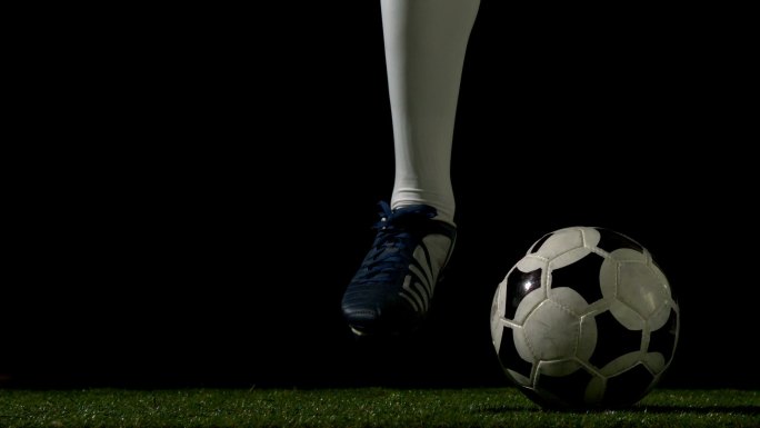 足球运动员在草地上以慢动作控制球