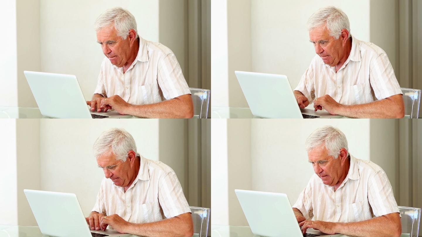 一个老男人在笔记本电脑打字