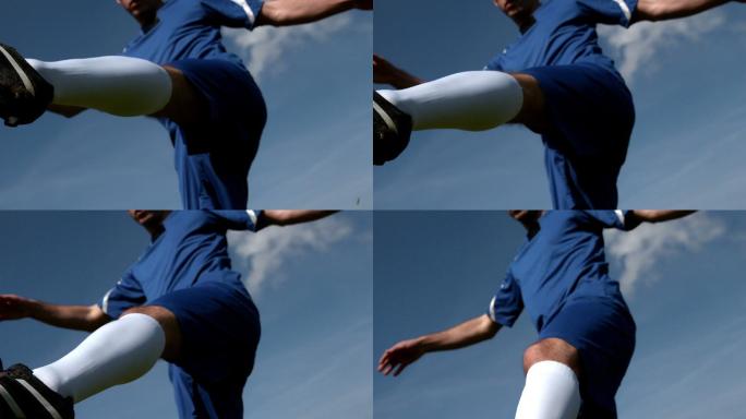 足球运动员在蓝天下慢动作踢球
