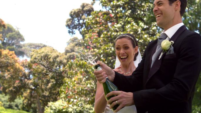 新郎和新婚妻子在慢镜头中开香槟
