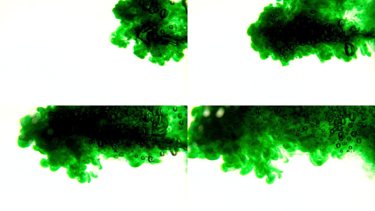 在慢镜头中，绿色墨水在白色背景上倒入水中