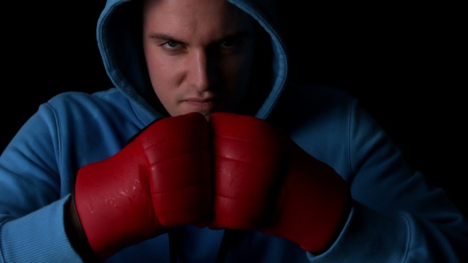 强硬的拳击手用红色的手套在慢动作拳在一起