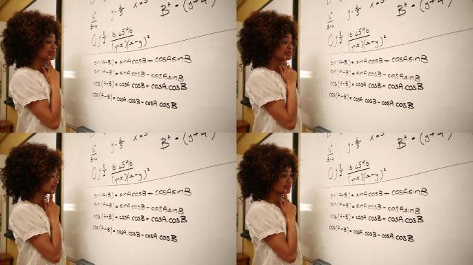 一个困惑的学生在大学的白板上看数学
