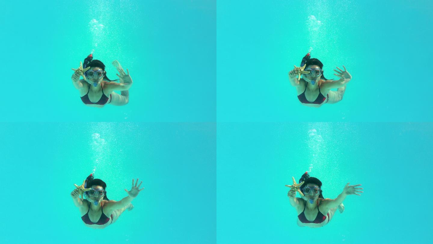 在慢镜头中，黑发女子戴着通气管在水下游泳