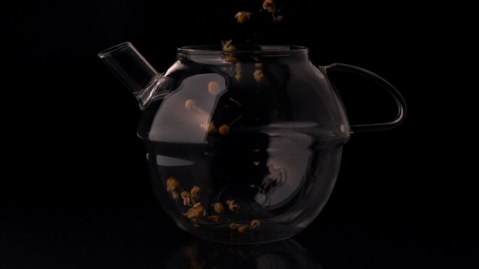 慢动作将凉茶倒入玻璃茶壶中