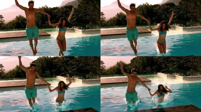 一对快乐的夫妇一起在游泳池里慢动作跳跃
