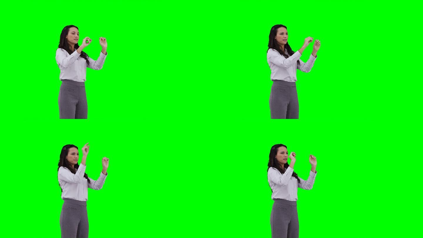 一个女人在绿色背景下使用虚拟界面
