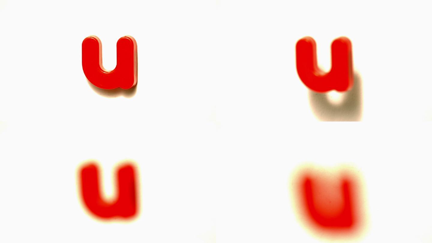 在慢镜头中，红色字母u从白色背景上脱离