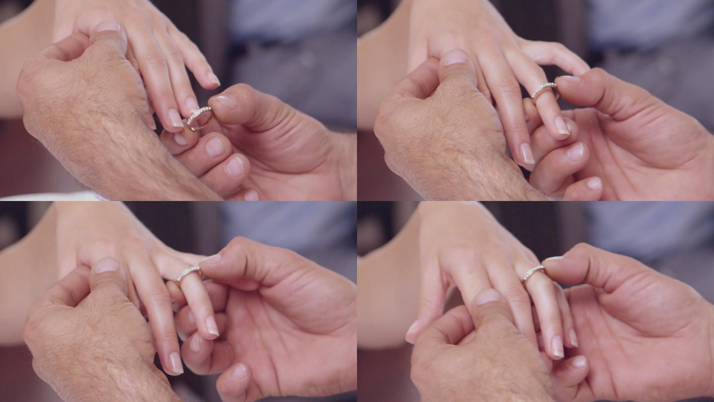 在慢镜头中，男人把戒指戴在女人的手指上