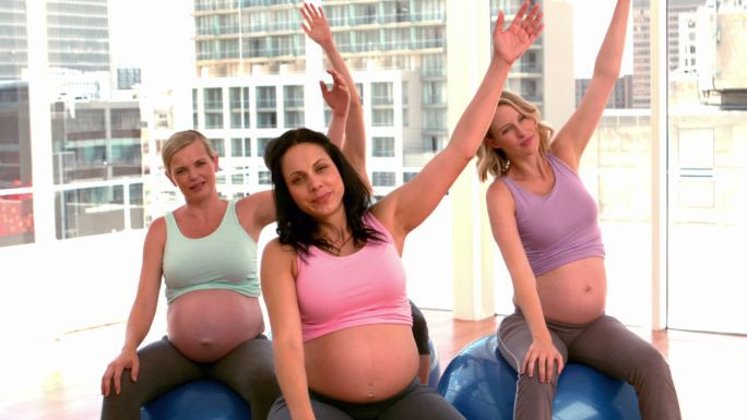 孕妇在健身房里慢动作做瑜伽