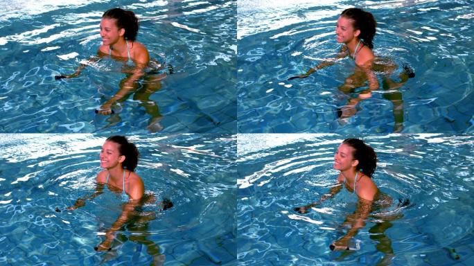 健身女子在游泳池做水中有氧运动的慢动作