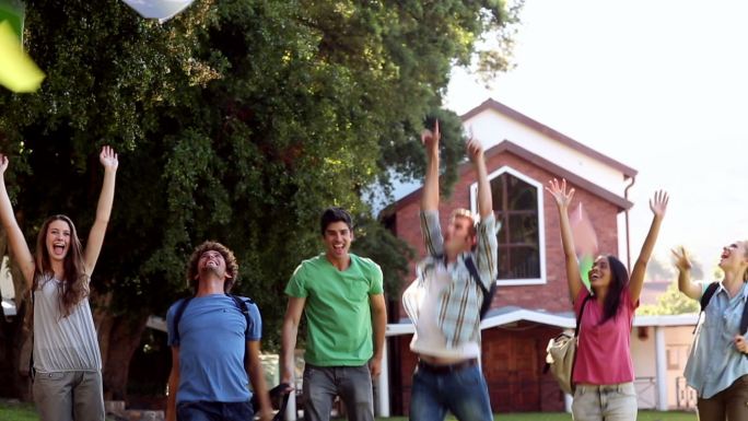 学生们在大学外面高兴地跳着