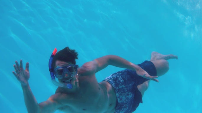 健康人戴着通气管在游泳池里慢镜头游泳