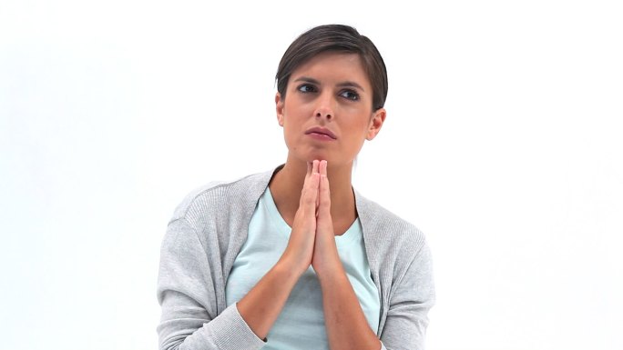 一个黑发女人正对着白色的背景祈祷