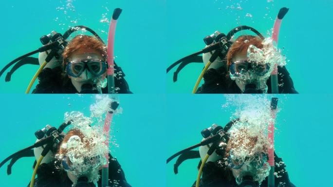 穿着水肺装备的女人在水下看着摄像机的慢动作