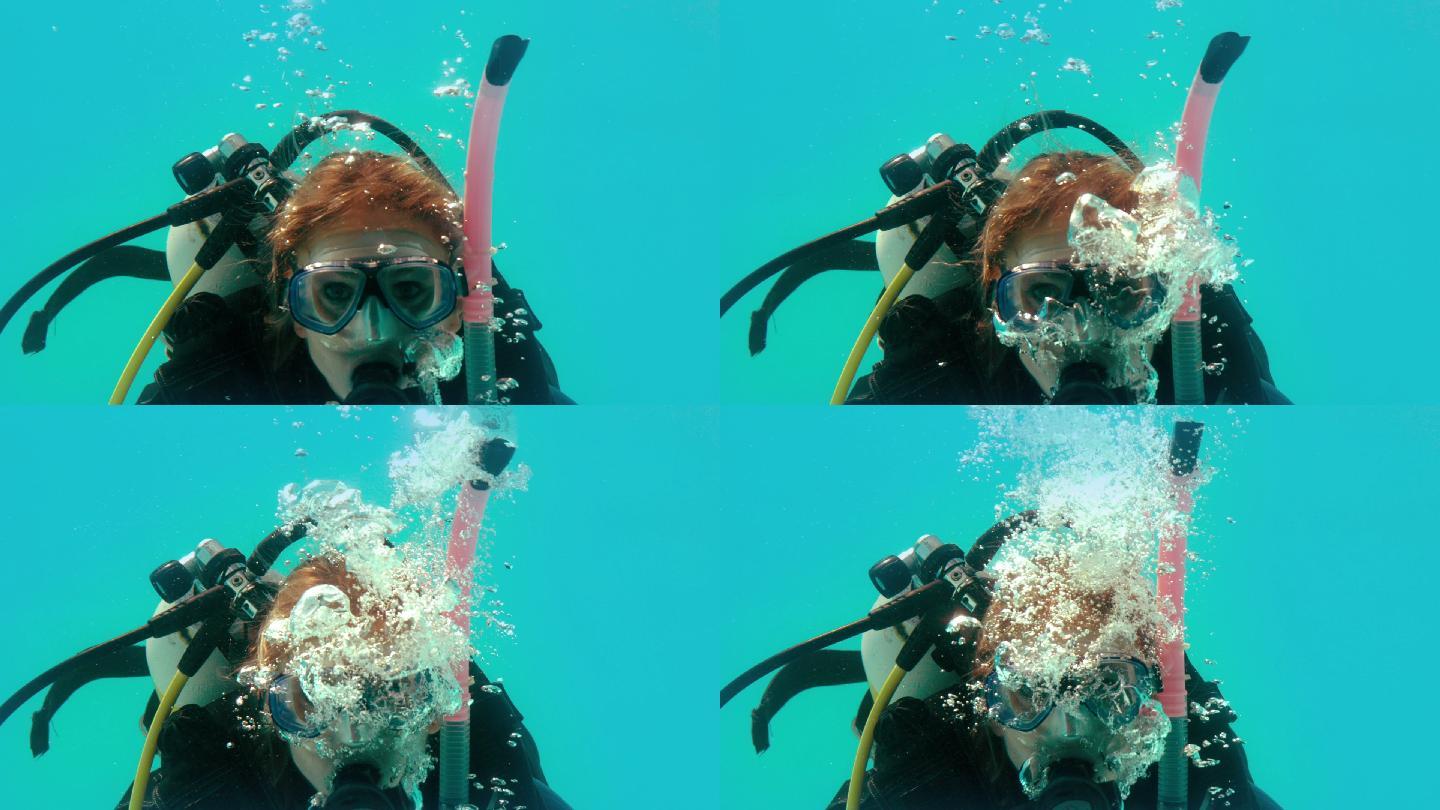 穿着水肺装备的女人在水下看着摄像机的慢动作