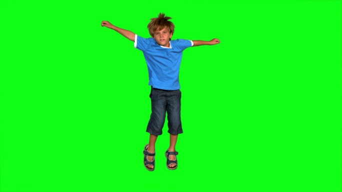 男孩在绿色屏幕上的慢动作跳跃