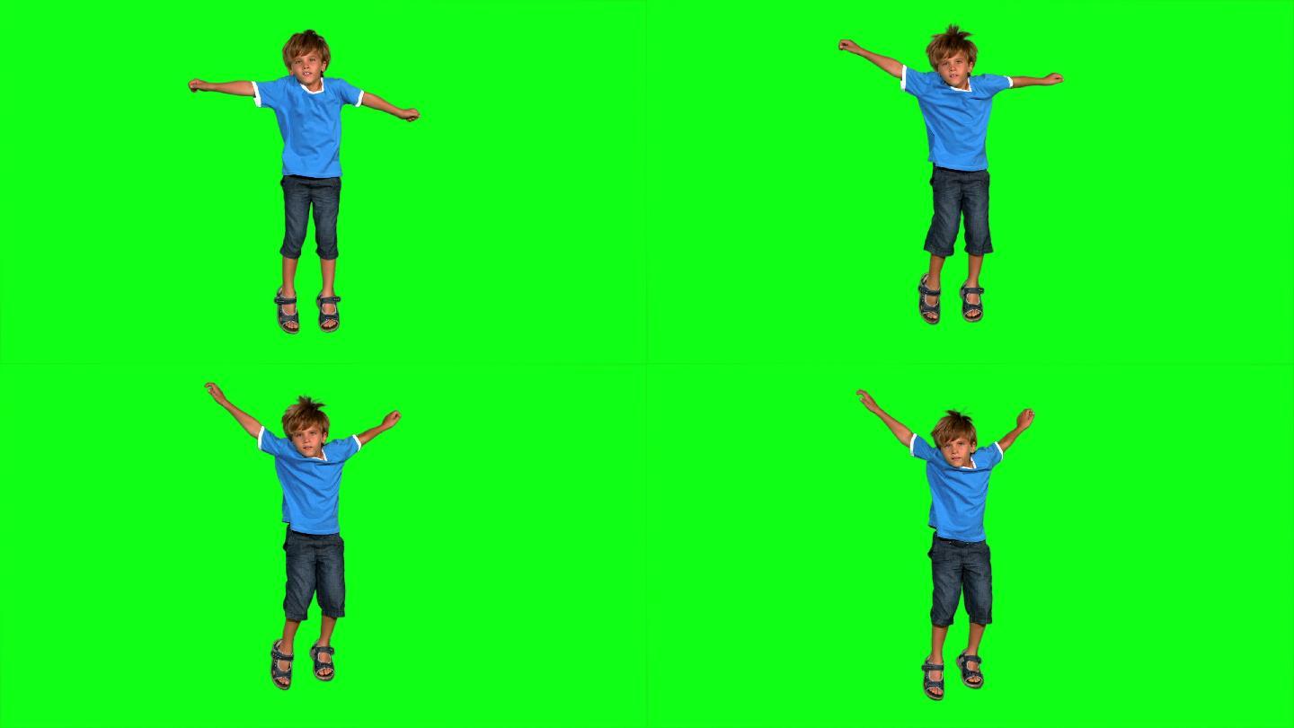 男孩在绿色屏幕上的慢动作跳跃