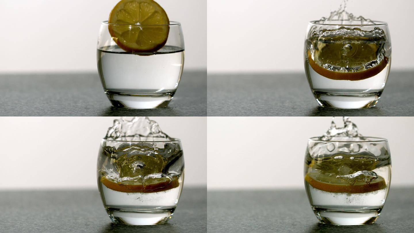 在慢镜头中，一片橙子落入一杯水中