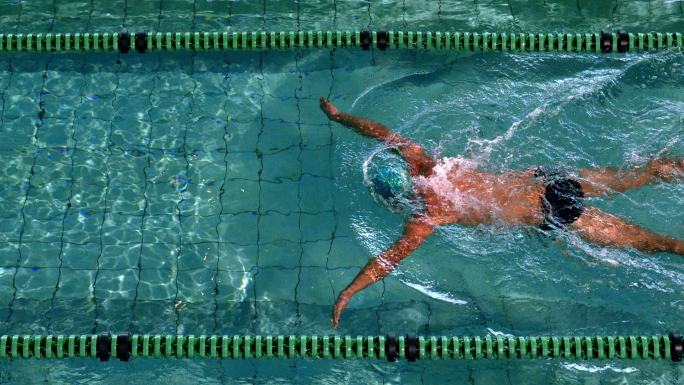 健康的游泳者在游泳池里用慢动作做蛙泳