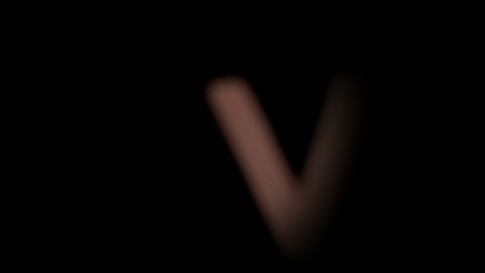 在慢镜头中，字母v在黑色背景上升起