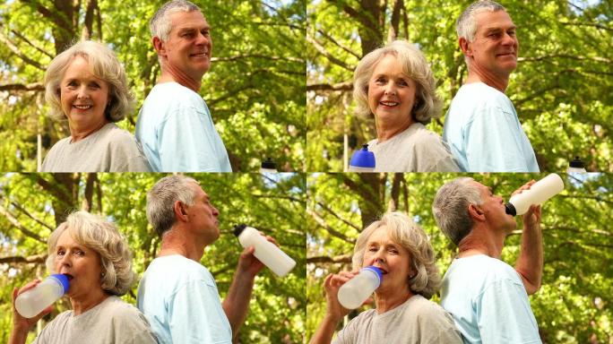 一对退休夫妇在阳光明媚的日子里在外面喝水
