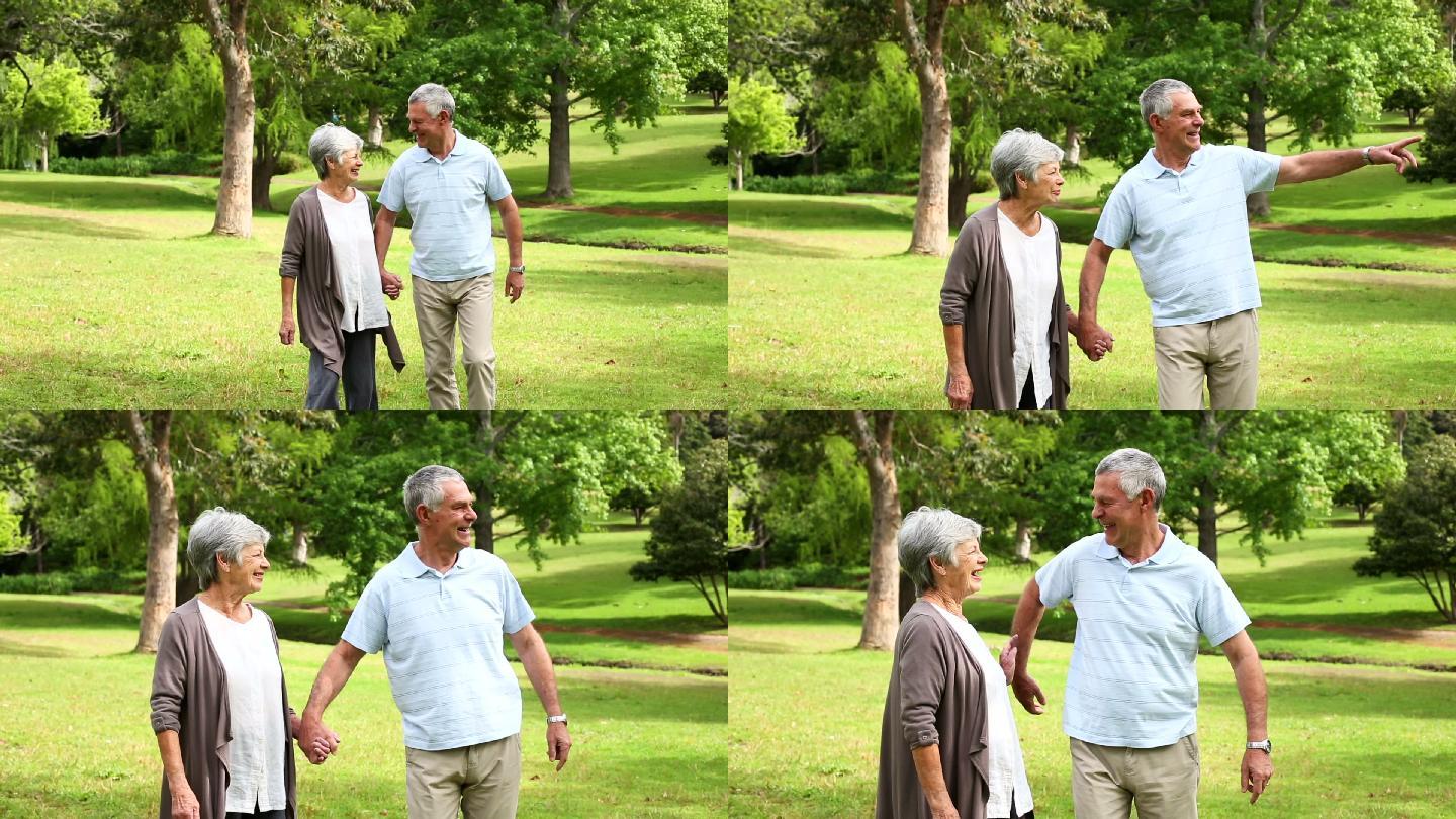一对退休夫妇在一个阳光明媚的日子一起在公园散步