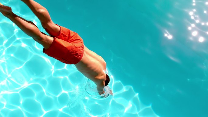 健身男子在游泳池里慢动作跳水