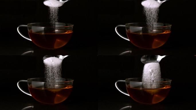 用茶匙将糖慢动作倒入一杯茶中