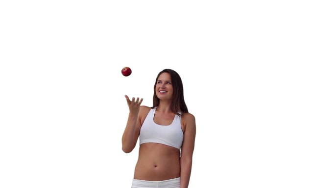 女人在白色的背景下玩着扔和接住一个球