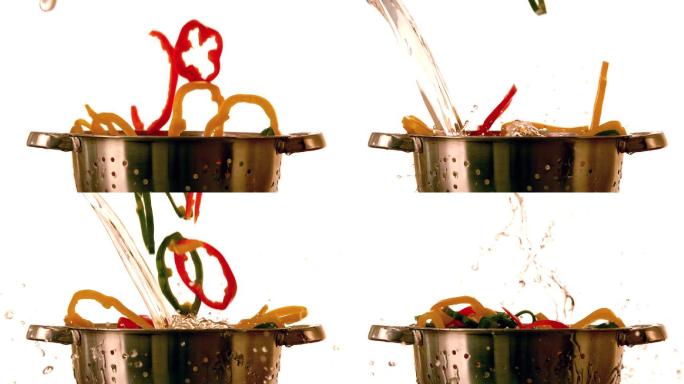 辣椒片和水以慢动作落入滤锅