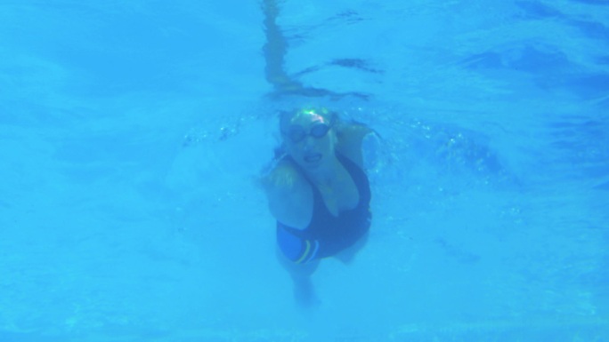 低角度视图的适合游泳者在游泳池做前划水