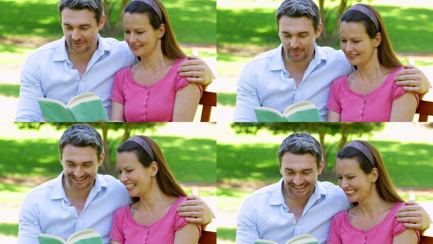 在一个阳光明媚的日子里，一对快乐的情侣坐在公园的长椅上一起看书