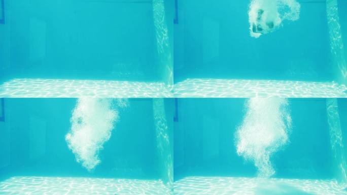 一个男人在度假时跳进蓝色的游泳池