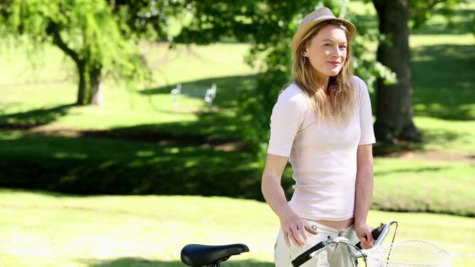 在一个阳光明媚的日子里，一个漂亮的女孩在公园里骑自行车