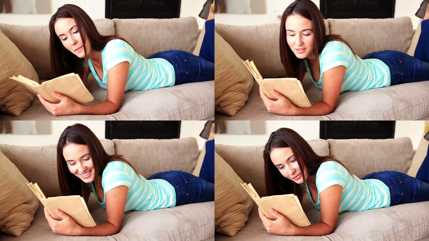 一个漂亮的黑发女孩在客厅的沙发上放松阅读