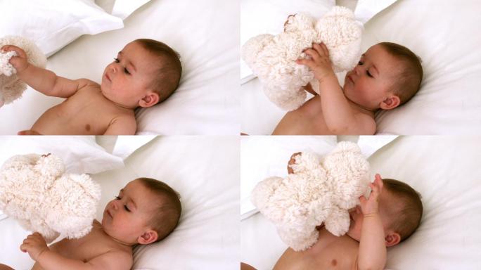 可爱的婴儿和泰迪熊在床上慢镜头