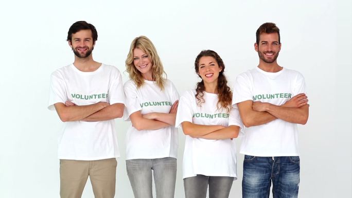 一组志愿者对着白色背景的照相机微笑