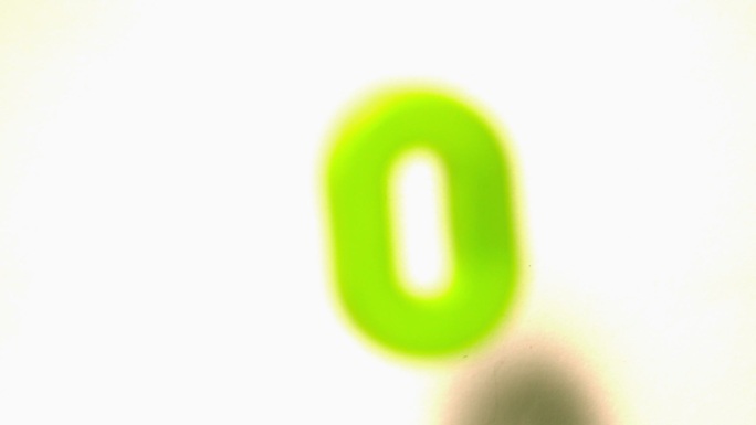 在慢镜头中，绿色数字零从白色背景中升起